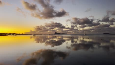 a stunning sunset over the sea on gunner's quoin island with the calm water creates a beautiful mirror effect with the sky