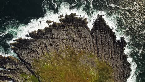 las olas chocan contra las rocas. toma ascendente cinematográfica lenta de la punta de la península de neist point.