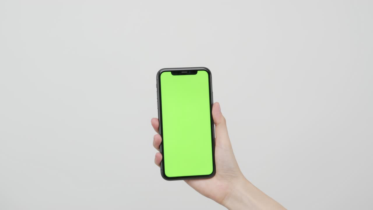 mano sosteniendo un teléfono inteligente con pantalla de tecla de croma y mostrando en el fondo blanco.