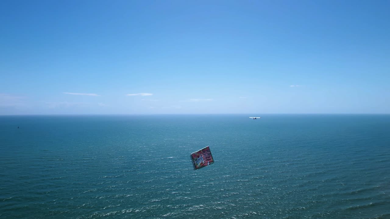 Aerial view following a airplane with a banner on the coast of Florida, USA