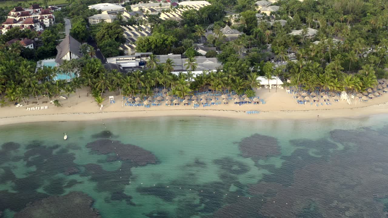 vista de drones del océano, sombrillas y playa de arena caribeña, playa grand bahia principe en la península de samana, república dominicana