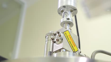 close-up of laboratory machinery parts with caution label