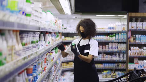 trabajadora que organiza los productos en los estantes del departamento de leche en la tienda de alimentos