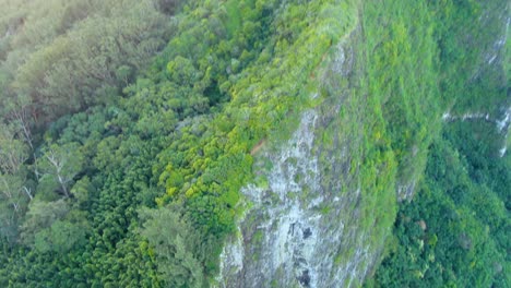 Aerial-tilt-up-shot-of-Koolau-mountain-during-dramatic-sunrise,-Hawaii,-USA