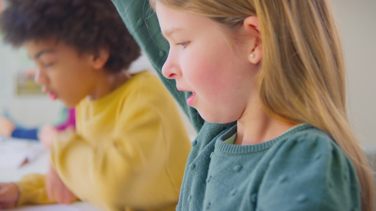 다문화 학생 들 이 교실 지리 수업 에서 질문 에 대답 하기 위해 손 을 들고 있다