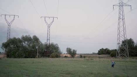 tres grandes postes eléctricos de metal en un campo cubierto de hierba