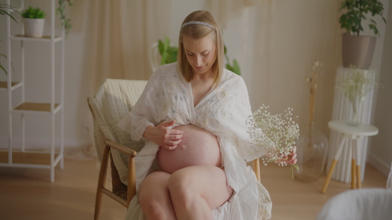 Pregnant Woman Sitting with Gypsophila Bouquet in Italian Lounge