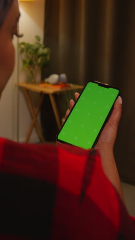 woman holding a phone with a green screen