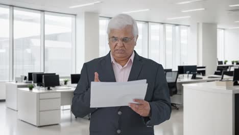 Angry-Indian-senior-manager-reading-reports