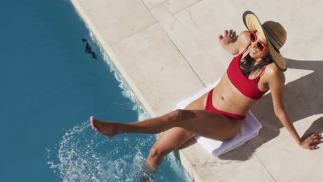 Mixed-race-woman-sitting-by-a-pool-at-home