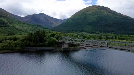 4k aerial drone footage near a road bridge above a loch river in scottish highlands scotland