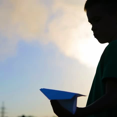 kid playing with flying paper plane