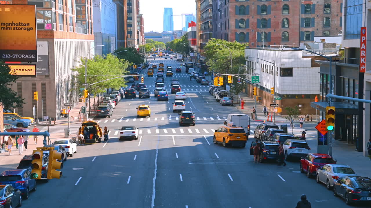 New York, USA, 4 August 2025: Busy intersection in Manhattan with cars and brick buildings. A view of Manhattan intersection with traffic, taxis, and old brick buildings