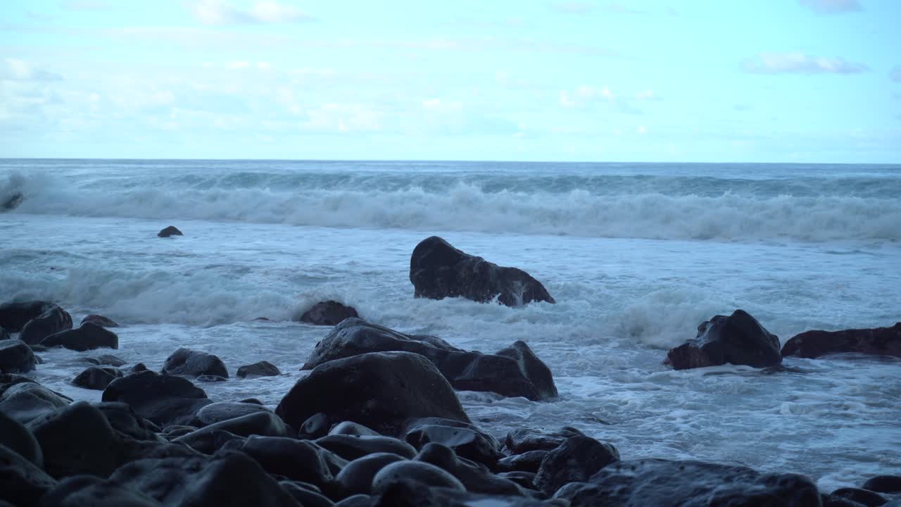 포르투갈 마데이라 섬의 북쪽 해안에 있는 바위에 충돌하는 파도의 총을 닫습니다