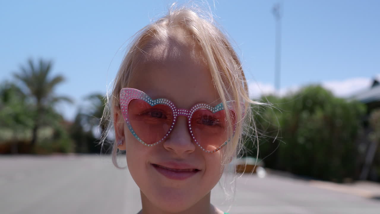 una niña linda con gafas de sol en forma de corazón