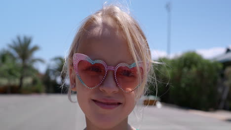 a cute young girl wearing heart shaped sunglasses