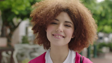 Primer-Plano-Retrato-De-Una-Joven-Y-Animada-Estudiante-Adolescente-Sonriendo-Juguetona-Mirando-A-La-Cámara-Linda-Mujer-Con-Un-Moderno-Peinado-Afro