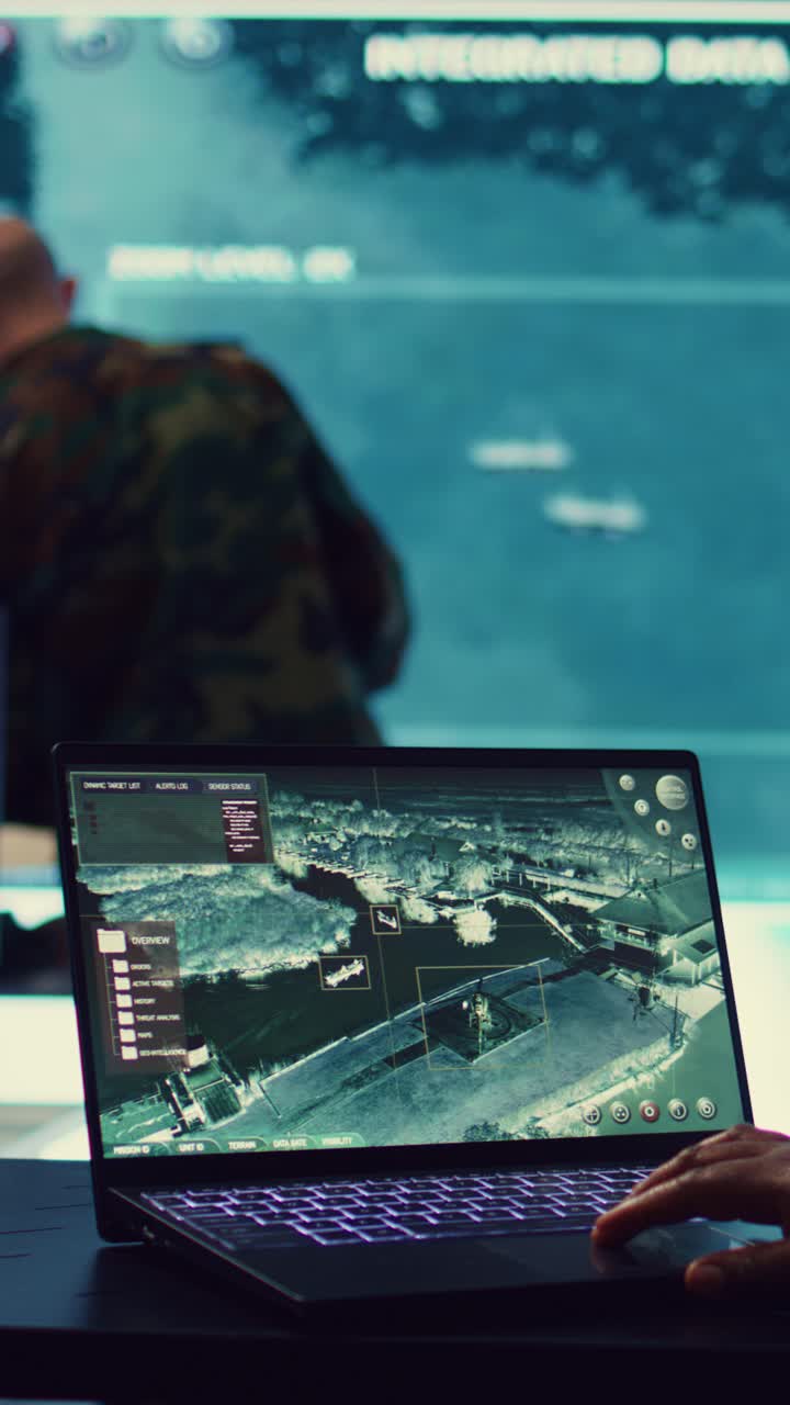 Person Operating Laptop with Satellite Map in Control Room
