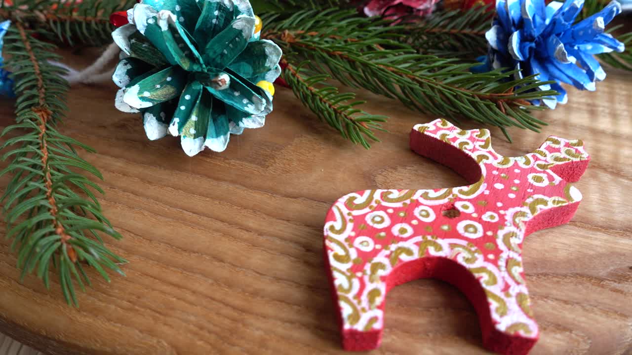 Handmade Christmas Ornaments and Fir Branches on Wood