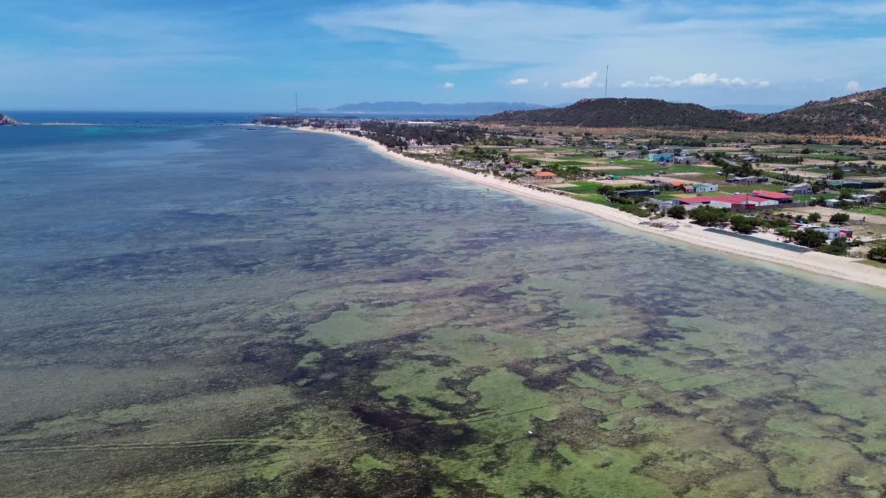 Aerial view of My Hoa Lagoon in Phan Rang, Vietnam, captured with a smooth pan left and slow movement at low altitude.
