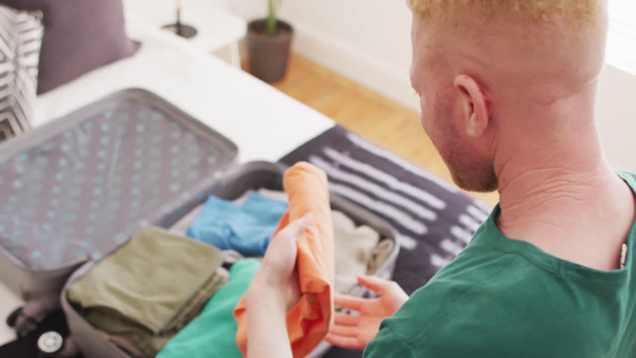 알비노 아프리카계 미국인 남성이 휴가를 위해 가방을  ⁇ 고 있습니다.