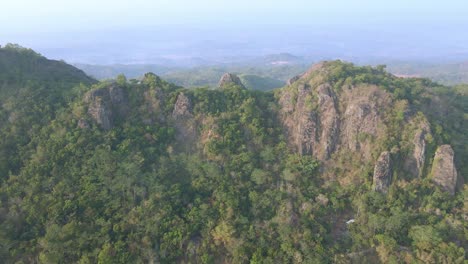 Aerial-view-of-towering-rock-formations-overgrown-by-trees