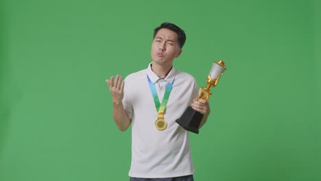 el ganador decepcionado sosteniendo un trofeo