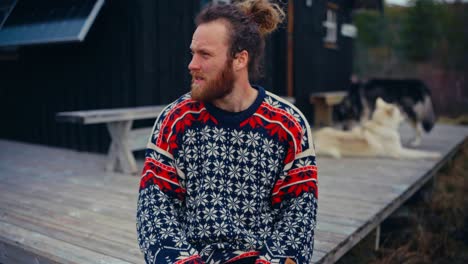 bearded man sitting in the wooden porch of his house. - closeup shot