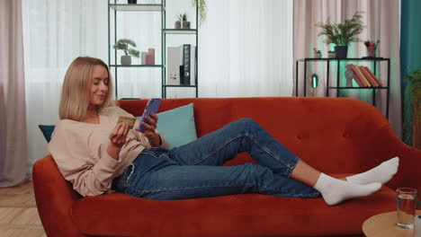 chica adicta a las compras usando tarjeta de crédito bancaria y teléfono inteligente, transfiriendo dinero, compras compras en línea