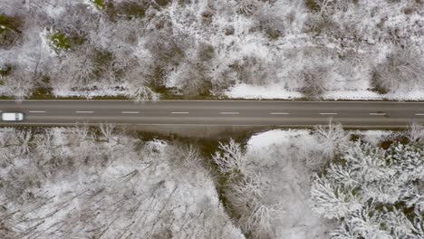 Carretera-Rural-De-Invierno-Con-Vistas-Desde-Arriba,-Coches-De-Conducción-Rápida-Que-Pasan-Por-La-Calle-Recta,-Vista-Superior-De-Drones