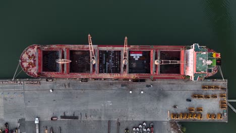 top down aerial of cargo ship at harbor dock