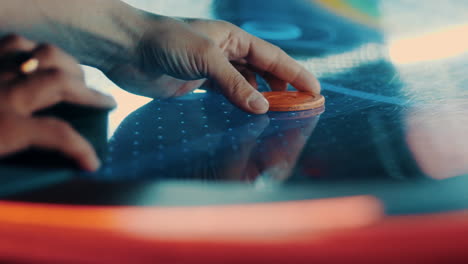 starting a game of air hockey by placing the puck on the table in slow motion