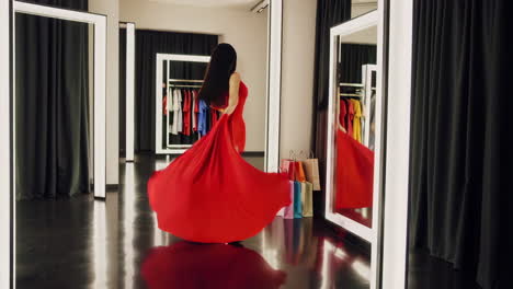 woman trying on a red dress in a fitting room