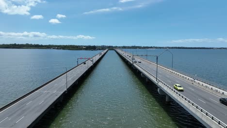 drone establishing static shot of ted smout memorial bridge, camera flying in-between both bridge lanes, watching cars as they drive across the bridge