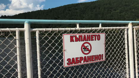 right sliding swimming forbidden cyrillic sign in the lake