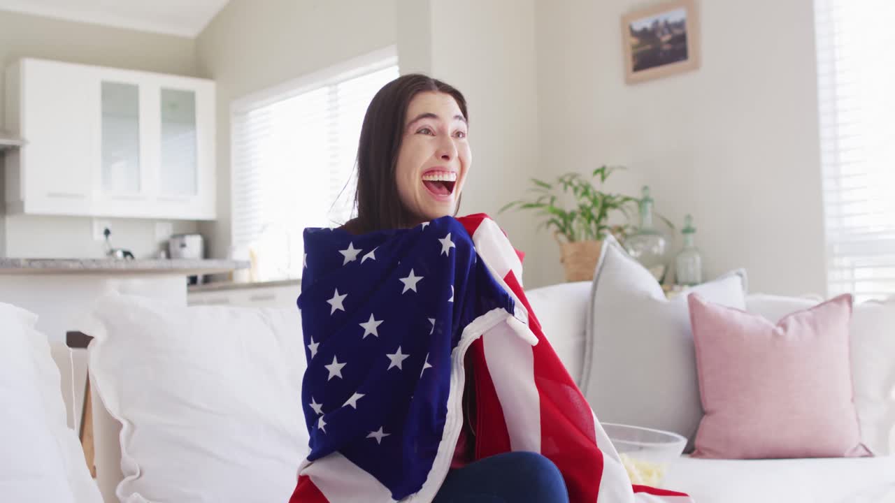 미국  ⁇ 발과 함께 소파에 앉아서 거실에서 tv를 보는 행복한 백인 여성