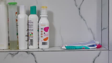 bottles of shampoo, toothpaste and toothbrush in the home bathroom