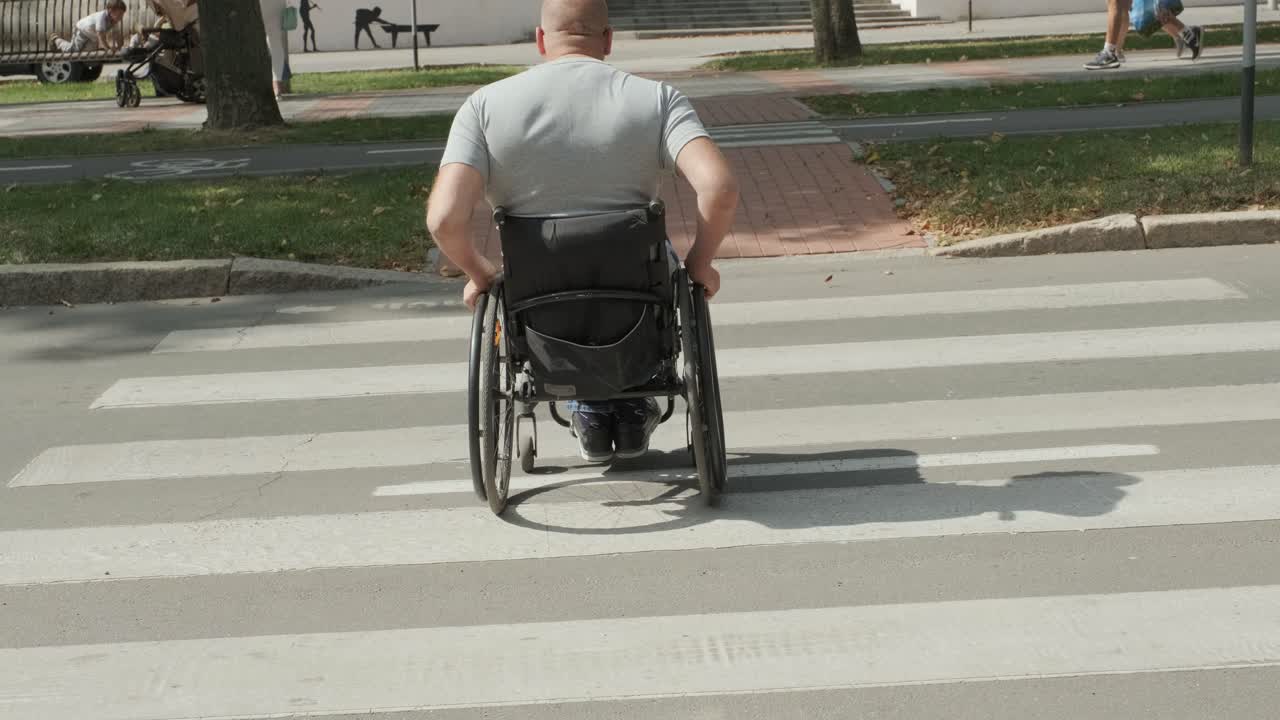 hombre con discapacidad en silla de ruedas cruzando la calle