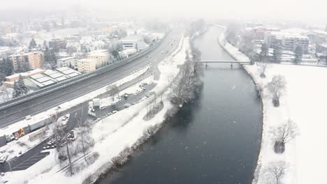 stationary shot of a river and a highway in a stormy snowy weather