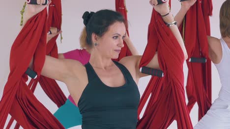 mujer fuerte concentrada sostiene una hamaca de yoga de mosca oriental