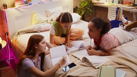 teenage girls studying together in a bedroom