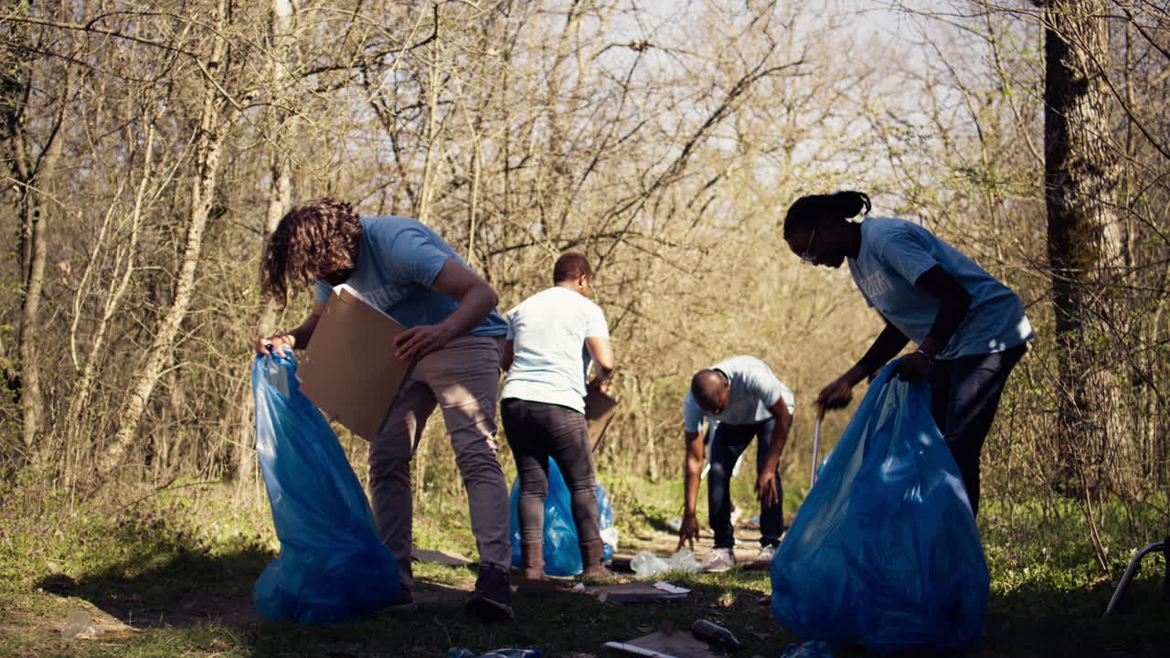 Team of volunteers collecting rubbish to fix pollution problem within the forest habitat
