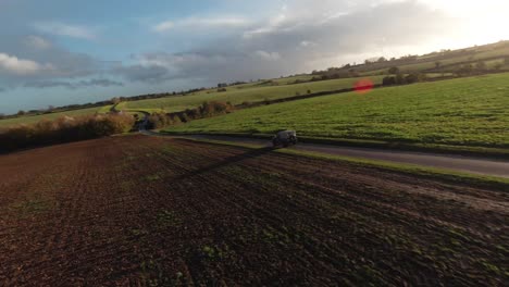 tomada de un avión no tripulado de un land rover conduciendo por el campo