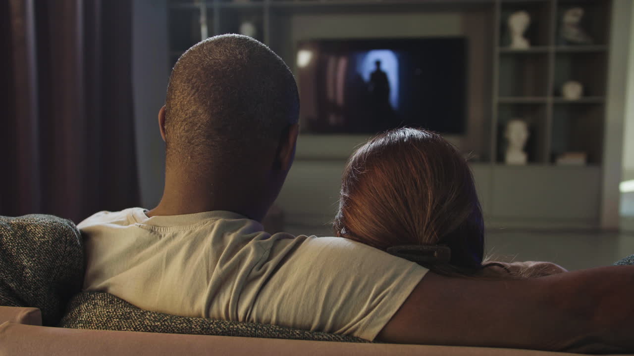 Couple watching TV at home
