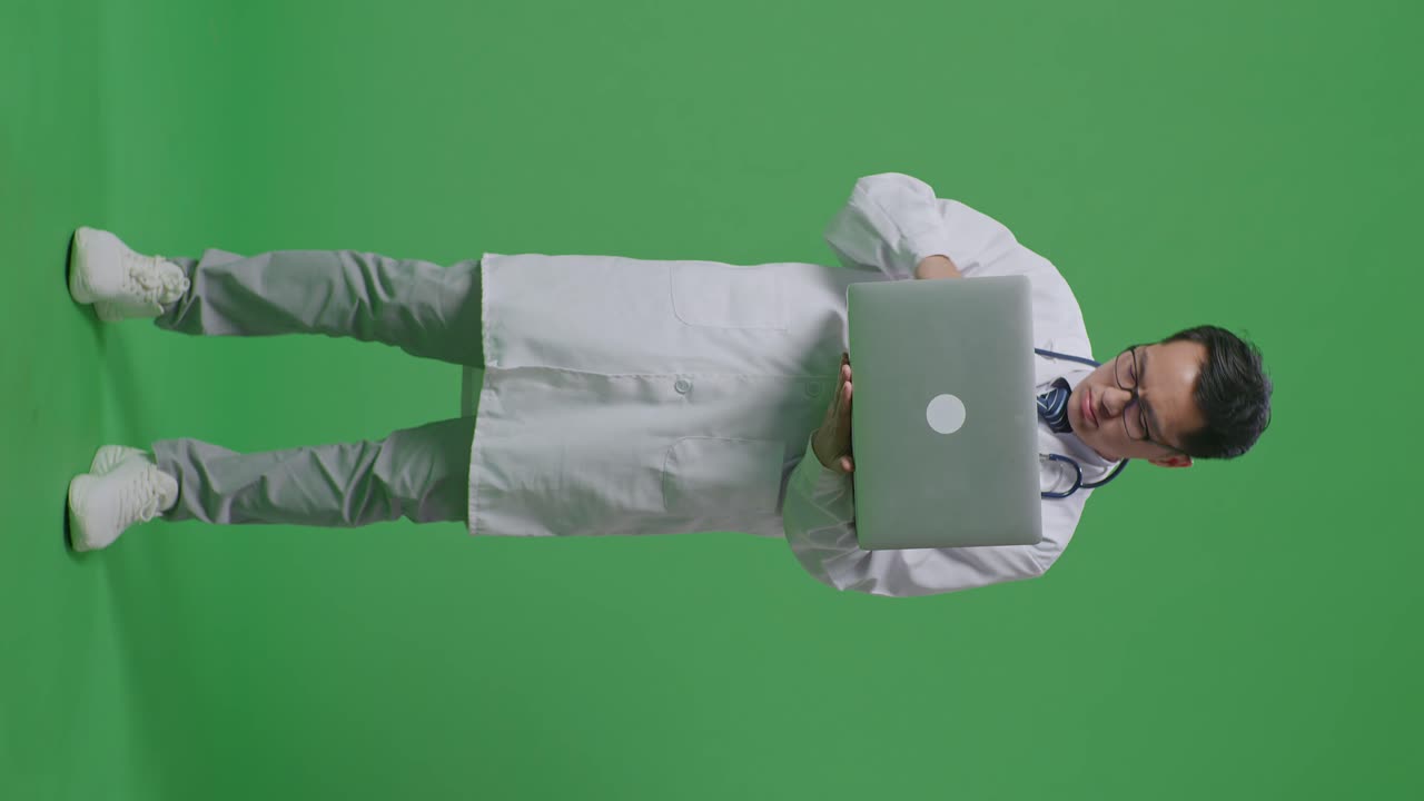 médico estresado mirando la computadora portátil