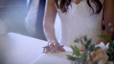 una novia recién casada firmando su licencia de matrimonio, legalizando oficialmente su unión