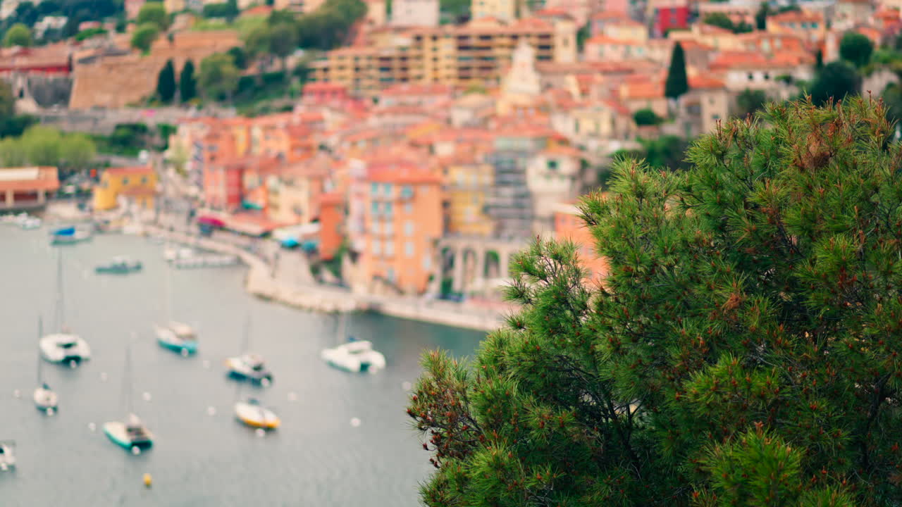 View of the colourful buildings of Villefranche sur Mer, France on the coast with small boats docked on the sea