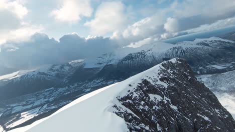 flying over mountain range covered in snow with majestic horizon view, fpv