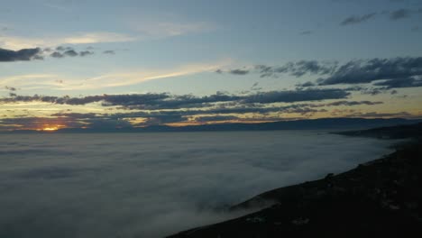 aerial over sea of fog covering lake léman at sunset lavaux - switzerland