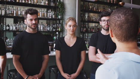 gerente de restaurante femenino con tableta digital dando al equipo hablar con el personal de espera